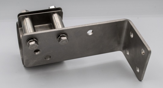 The microphone clamp is attached to the bracket via the pivot hole and the perpendicular hole. It is mounted to the external face of the bracket to allow room for the microphone's Ethernet cable.